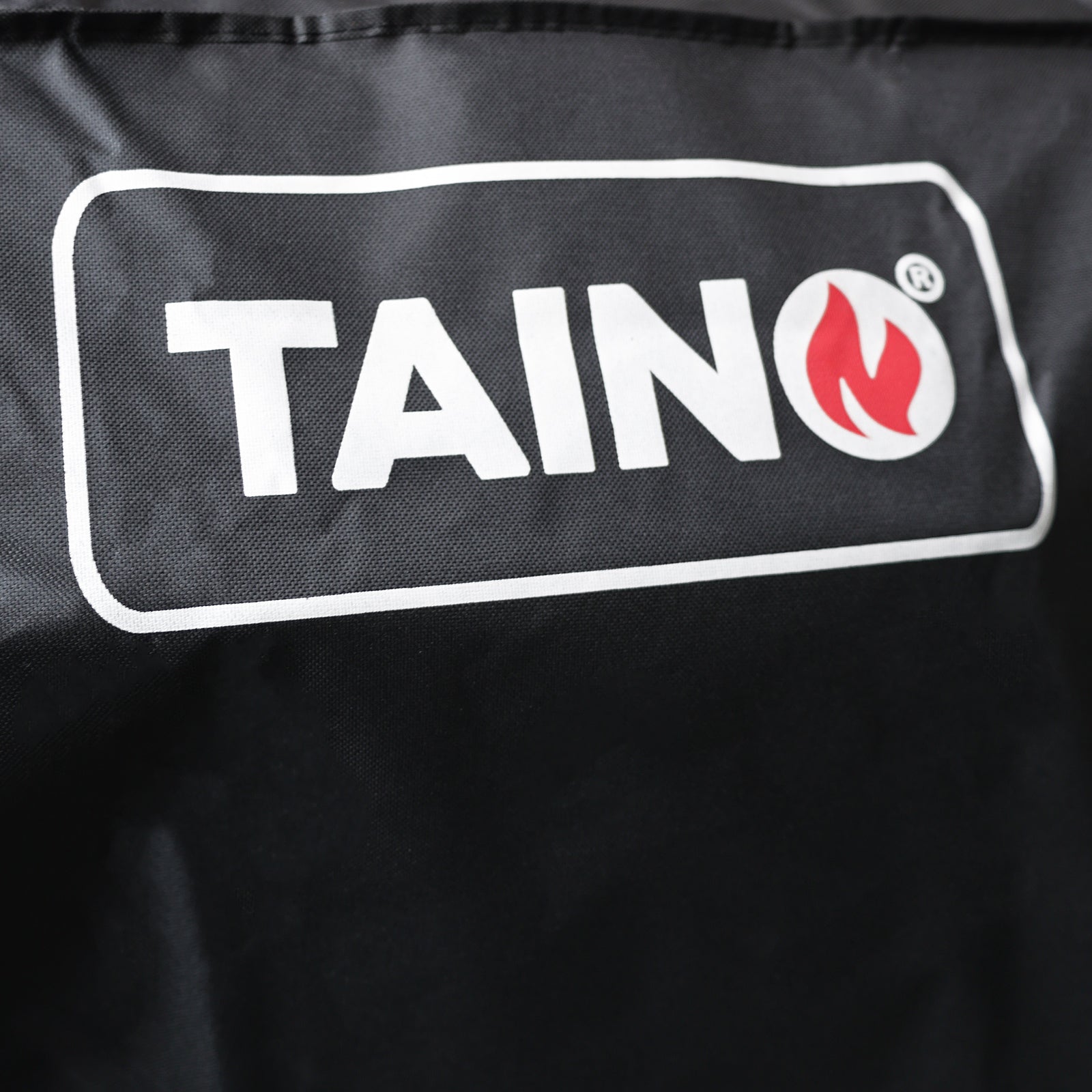 TAINO-Logo mit roter Flamme auf der TAINO HERO Abdeckhaube