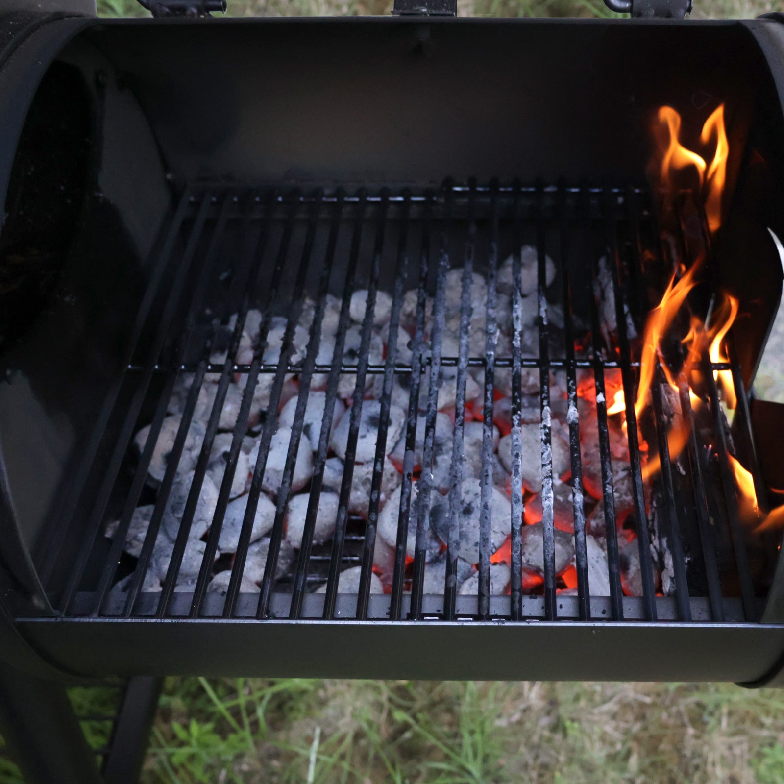 Räucherkammer des TAINO YUMA Smoker gefüllt mit glühenden Kohlen