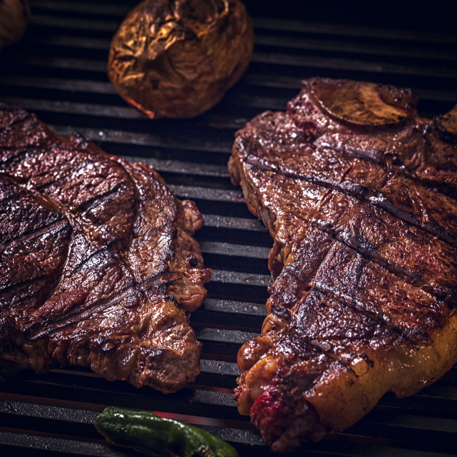 Zwei saftige Steaks braten auf einem Gusseisenrost
