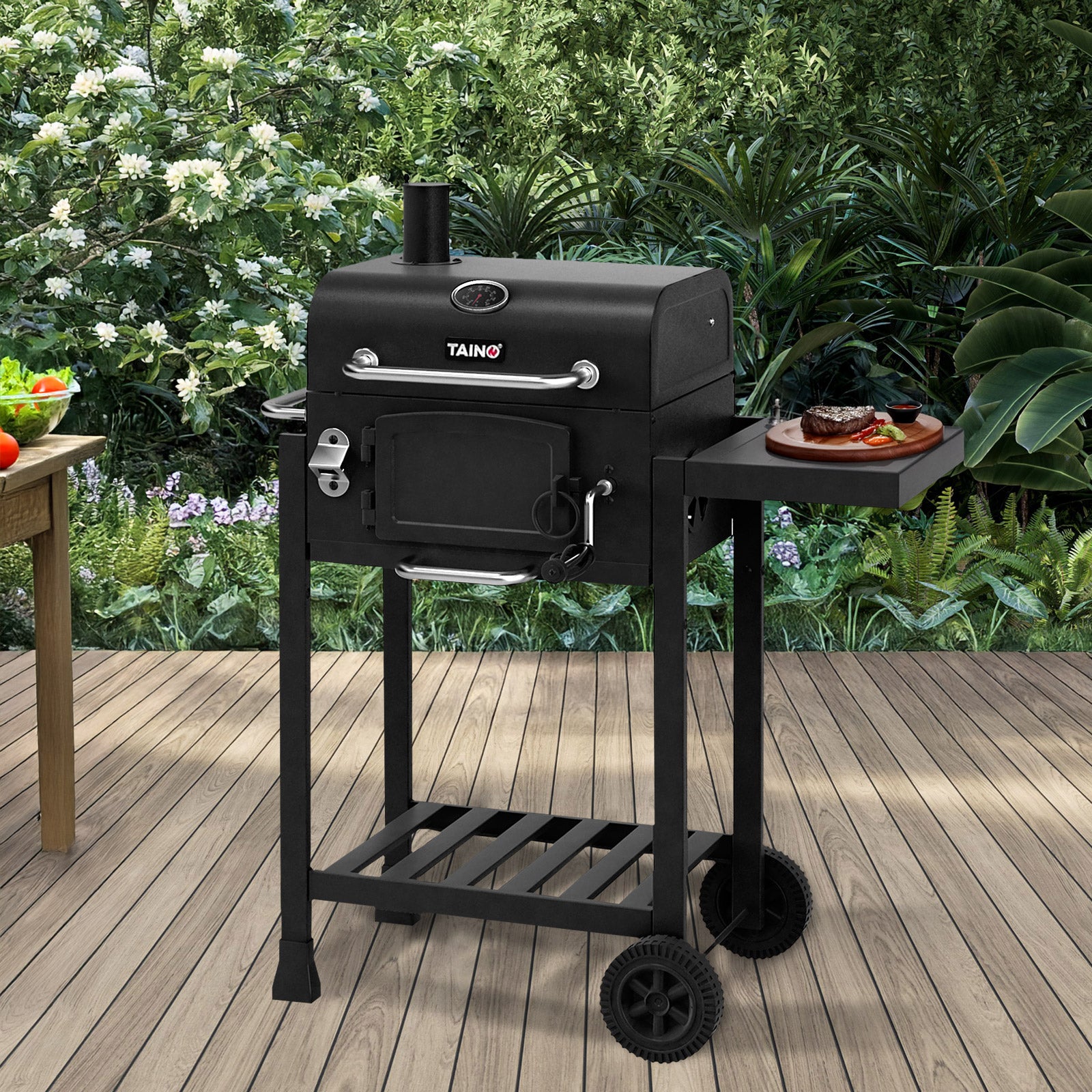 TAINO HERO Holzkohlegrill auf Terrasse mit Steak auf dem Seitentisch
